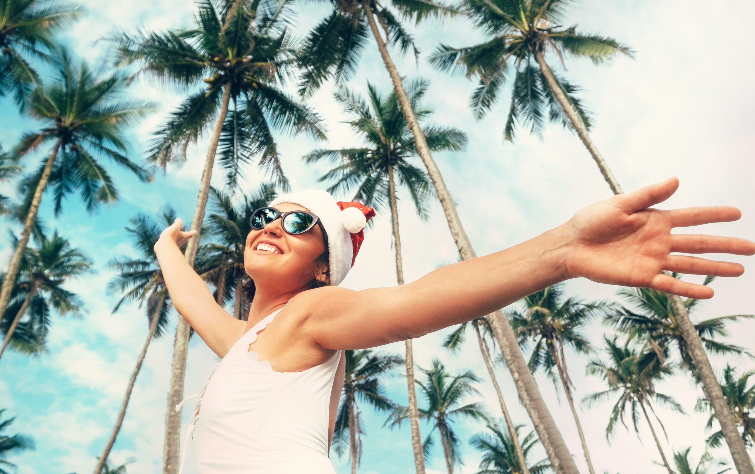 woman in Santa hat with palm trees