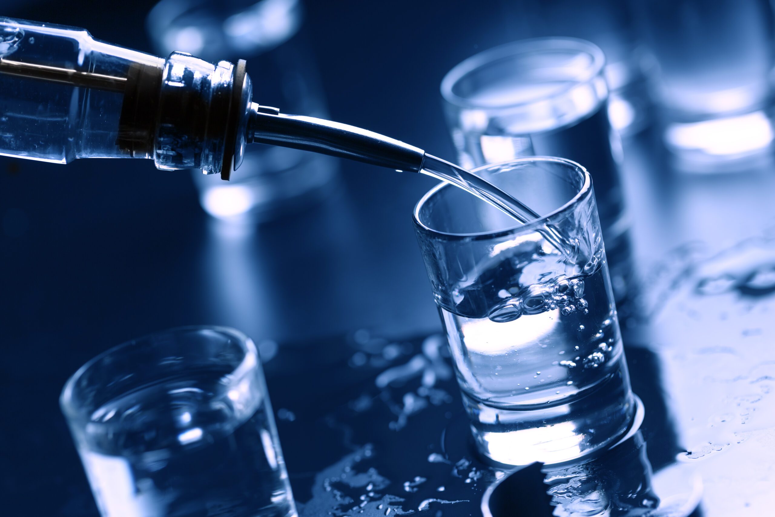 vodka being poured in shot glasses