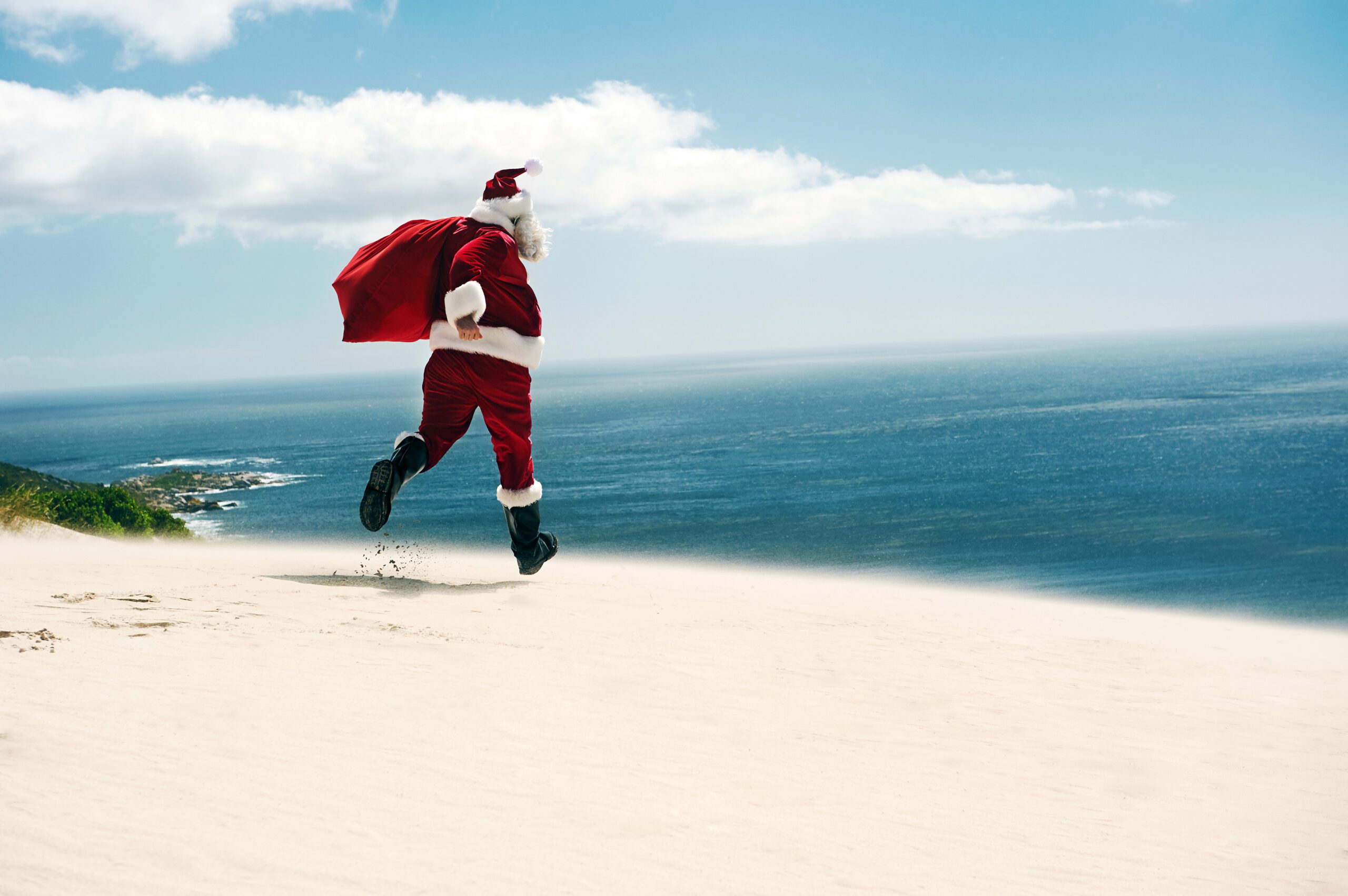 Santa running into the water on Christmas in July